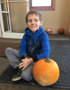 Boy sitting with pumpkin