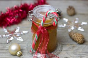 jar with baking ingredients in it and candy cane and ribbon decorations