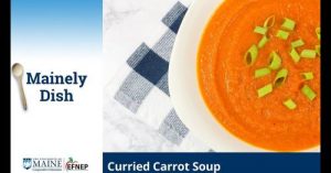 bowl of carrot soup and a black and white napkin on a table