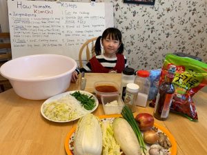 young girl with food and cooking supplies demonstrating how to make