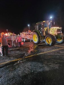 night parade with lighted tractor and youth