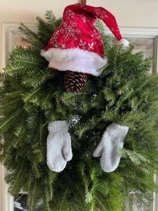 evergreen wreath with red hat and gray mittenss