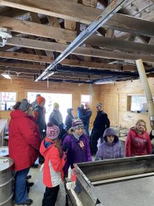 youth and adults learning about making maple syrup