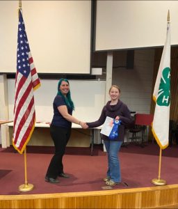female 4-H member being congratulated by a 4-H staff person at the state public speaking tournament