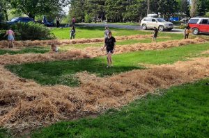 group of youth gardening wth mulch hay