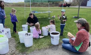 kids preparing to plant vegetables in a bucket
