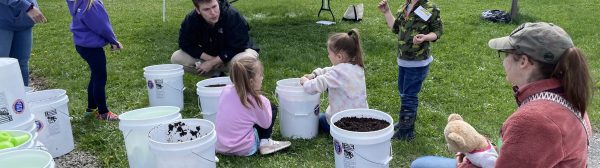 kids preparing to plant vegetables in a bucket