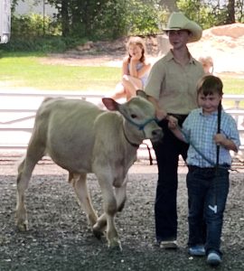 two youth walking cow