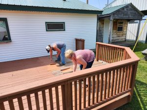 volunteers painting the deck of the food booth