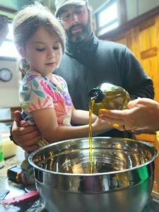 man helping girl with soap making