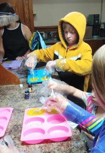 youth making soap putting in molds