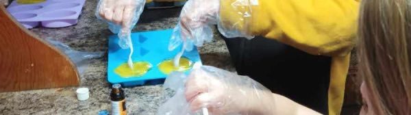 youth making soap putting in molds