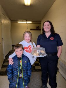 one adult two youth with giving away snacks