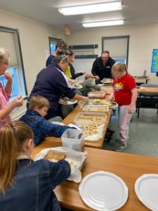 youth and adult preparing food to giveaway