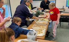 youth and adult preparing food to giveaway