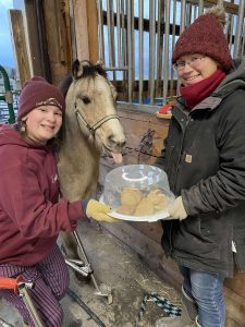 adult youth and horse with a goody tray