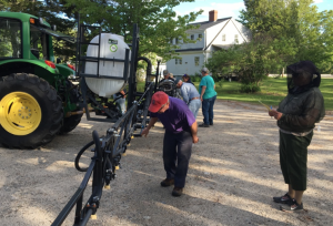 Growers inspecting sprayer nozzles