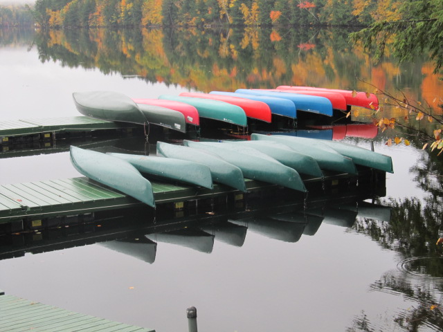 canoes stacked on two docks at water's edge