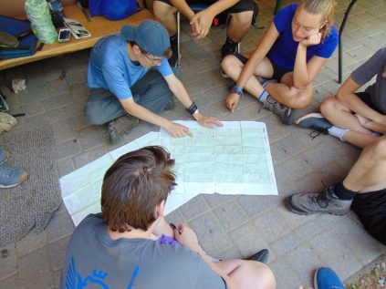 Campers and staff researching a map