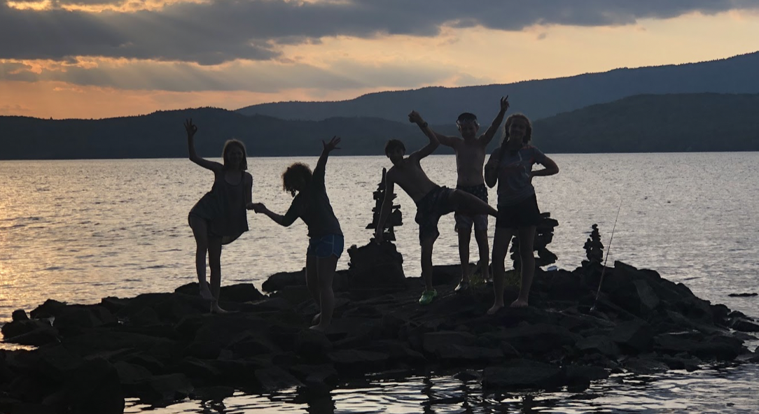 Image of students on a rock in a pond in Maine