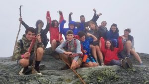 a group of hikers with a mentor who have reached the top of a mountain