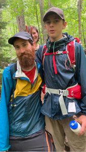 mentor and participant on a group hike in the woods