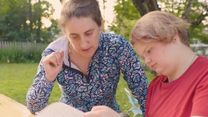 mentor working with a participant, looking at a book