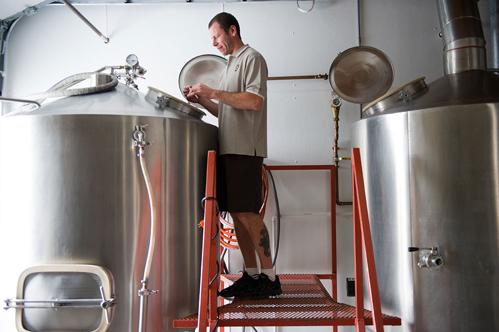 Beer producer checks fermenting barrels