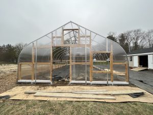 High tunnel with polycarbonate end walls and a wood frame