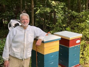 Beekeeper Peter Richardson with two of his hives