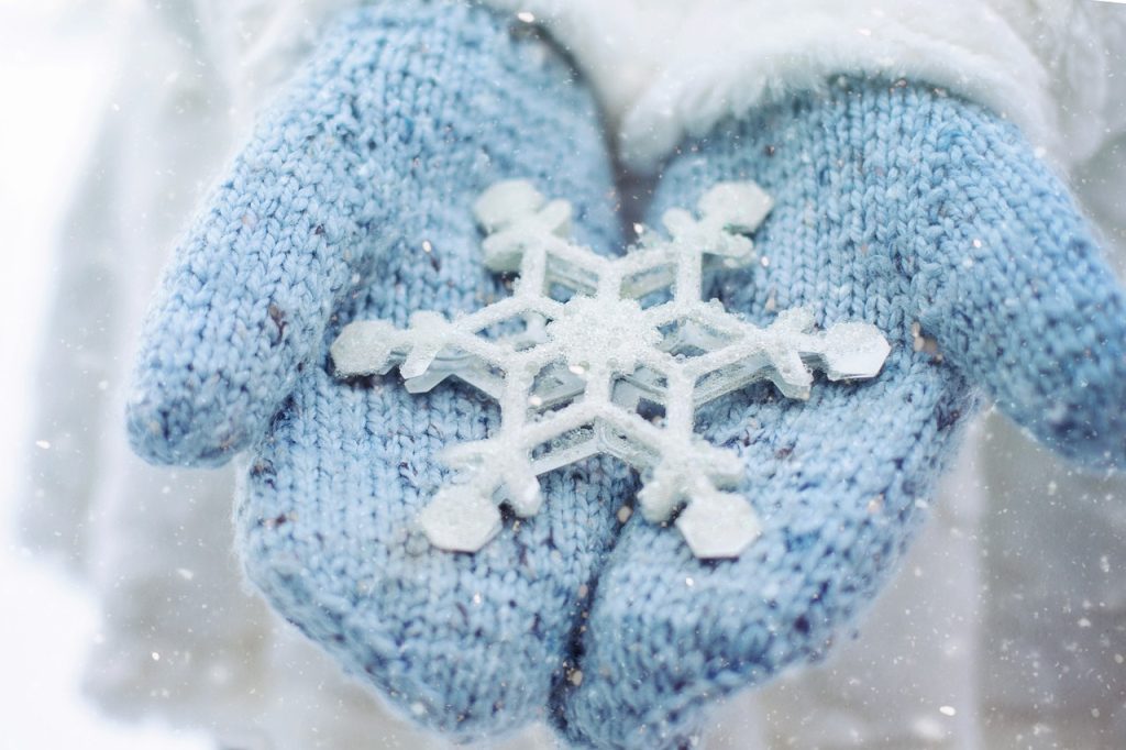 Mittened hands holding a snowflake; photo from Pixabay