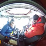 Lynn drives the Piston Bully as Seth Campbell looks at the data along the route to their new camp.