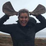 Kit Hamlin holds sea lion scapula bones up to her head to mimic moose antlers.
