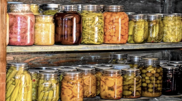 a row of colorful canned foods on a wooden shelf