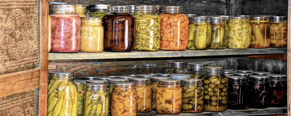 a row of colorful canned foods on a wooden shelf