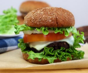 Black bean burger with lettuce, tomato, and cheese on a burger bun.