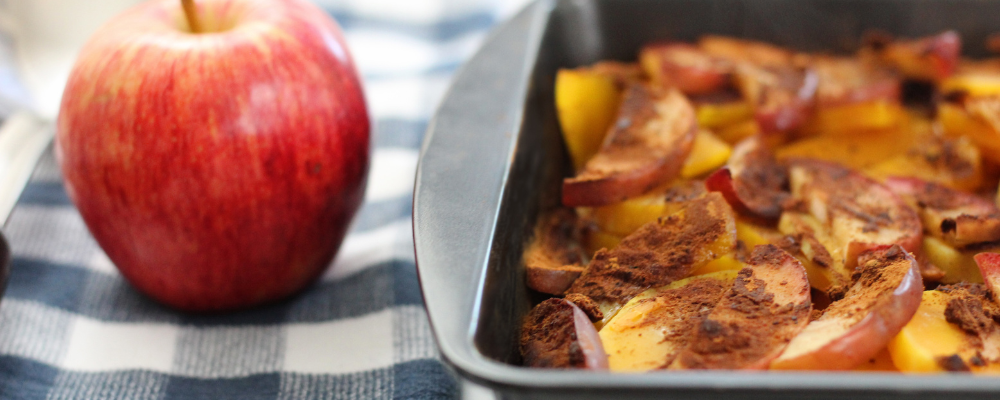 Apple-Squash Casserole in a pan and 1 red apple on table