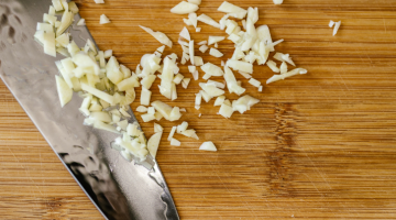 Knife with Chopped Garlic on Cutting Board