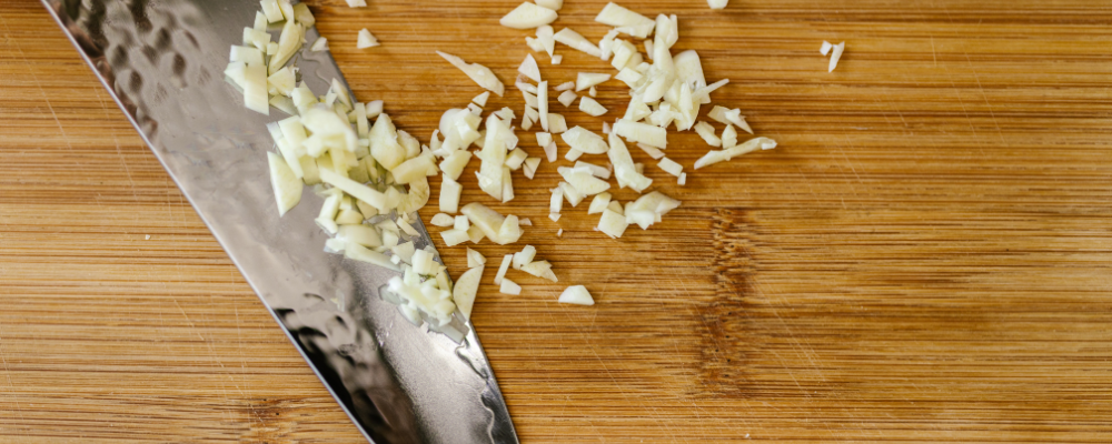 Knife with Chopped Garlic on Cutting Board