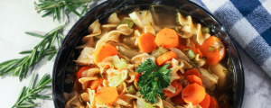 Chicken Noodle Soup with rosemary around bowl