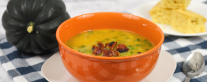 acorn squash soup with bacon and corn bread in the background