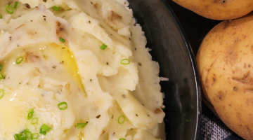 Potatoes next to mashed potatoes in a bowl.