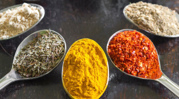 Five spoonfuls of different spices with a variety of colors.