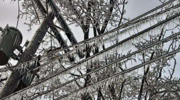 Frozen power lines with several icicles