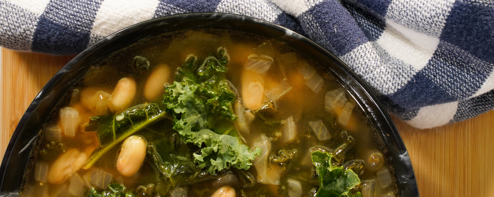 Kale and white bean soup in a bowl.