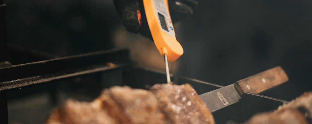 A food thermometer taking the internal temperature of steak.