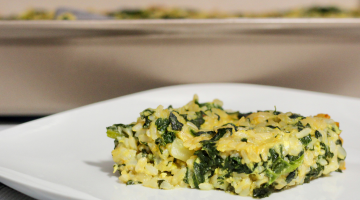 Piece of spinach-rice casserole on a plate with a baking dish in the background