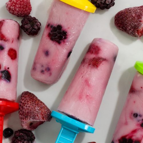 Four ice pops with berries.
