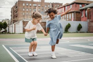 Little Girls Holding Hands and Jumping on a Court 