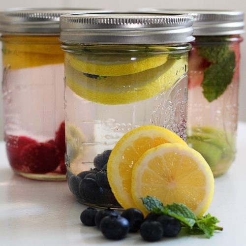 mason jars of flavored water filled with various fruits